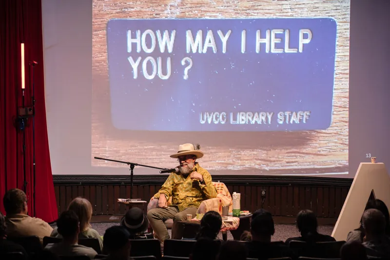 Dave Olson's slide shows a "HOW MAY I HELP YOU?" library staff sign.