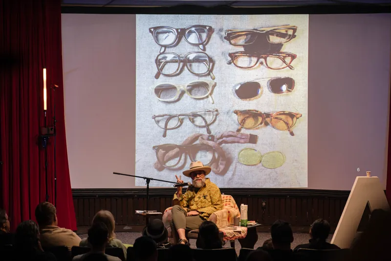 Dave Olson's talk opens with archival images and story slides behind him — Closer on the mic.