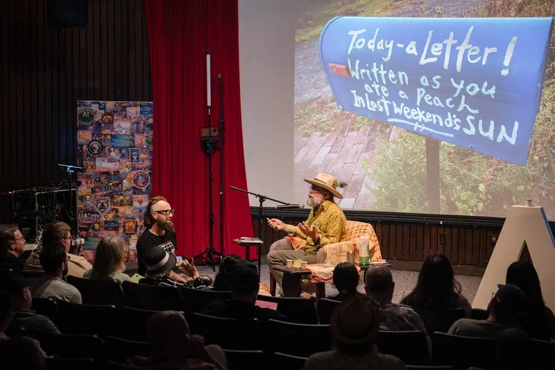 An on-stage conversation with Dave Olson — two chairs, mic, and a listening room — Closer on the mic.