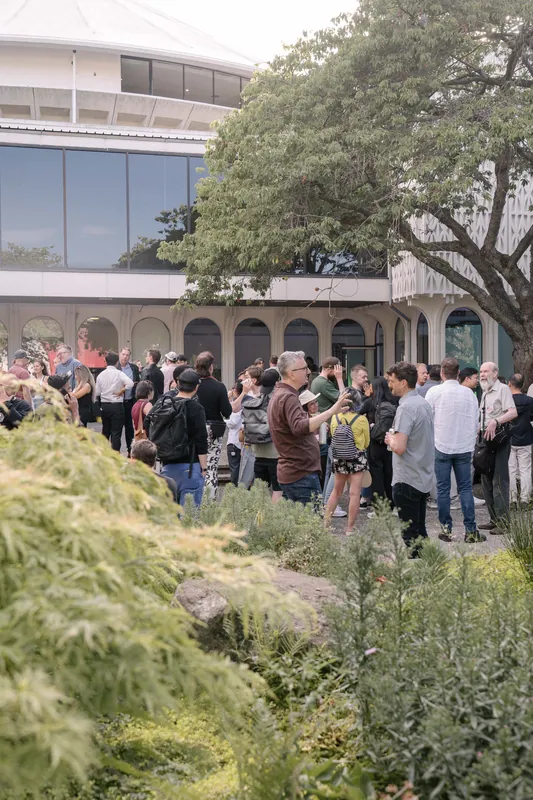 Crowds fill the courtyard for outdoor networking in the late-day light.