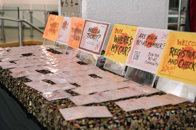 Rows of name badges wait under a yellow WELCOME REGISTRATION AND CHECK-IN sign.