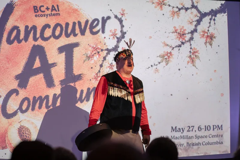 An Indigenous welcome unfolds on stage as the audience settles in — Wider angle.
