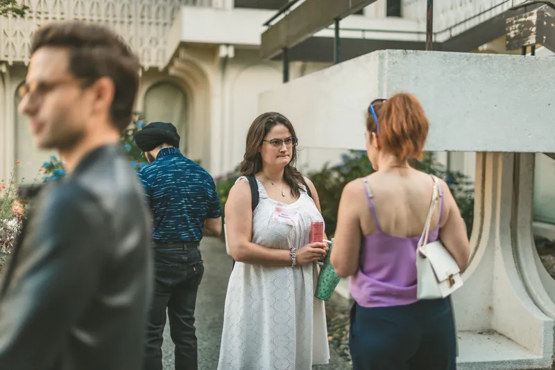 Two guests catch up over drinks before doors open.