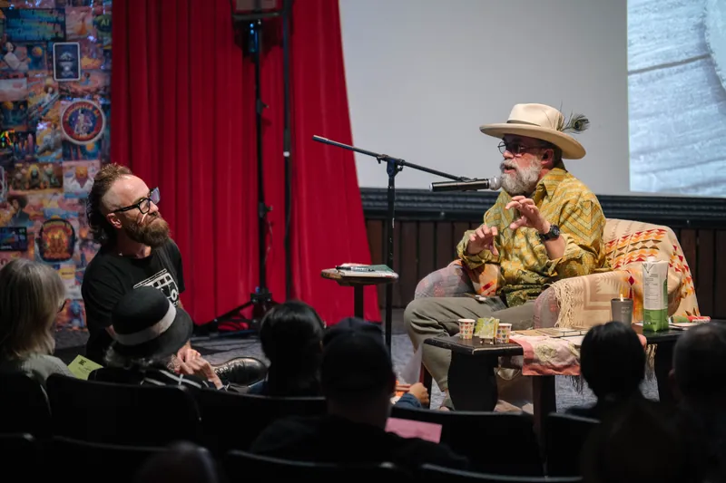 An on-stage conversation with Dave Olson — two chairs, mic, and a listening room — Stage-right view.