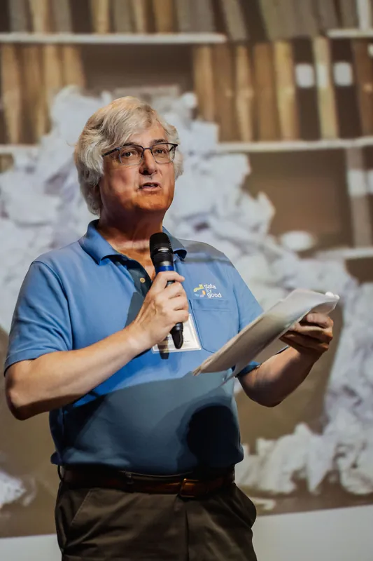 A Data for Good presenter reads from notes during the stage presentation.