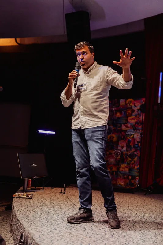 Taleeb Noormohamed extends one arm in a full-length stage portrait.