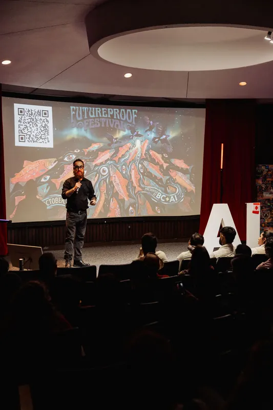 A wide stage view shows the host presenting the Futureproof Festival artwork.