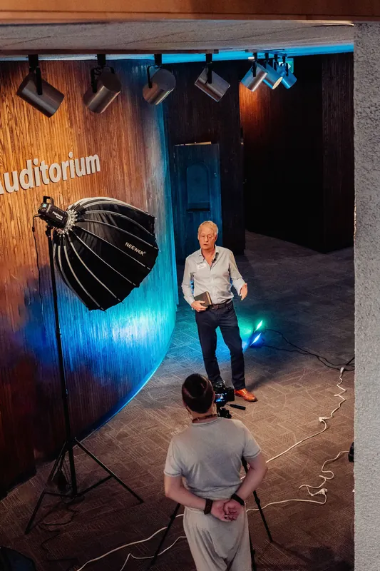 A wide view shows the portrait setup and blue-lit venue wall.