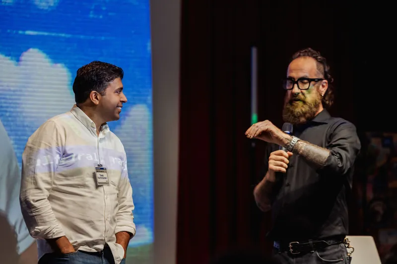 Taleeb Noormohamed waits onstage during the speaker handoff.