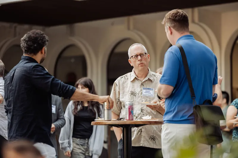A small group continues a conversation at a reception table.