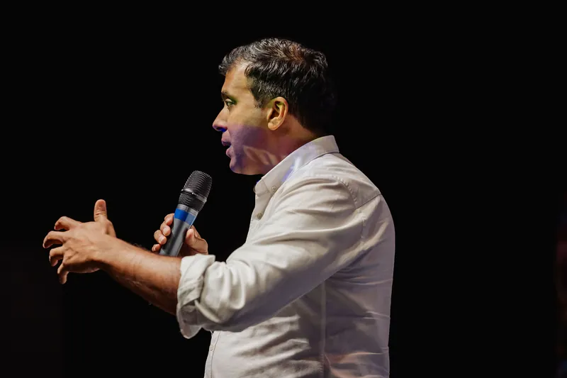 Taleeb Noormohamed extends one hand while continuing his remarks.