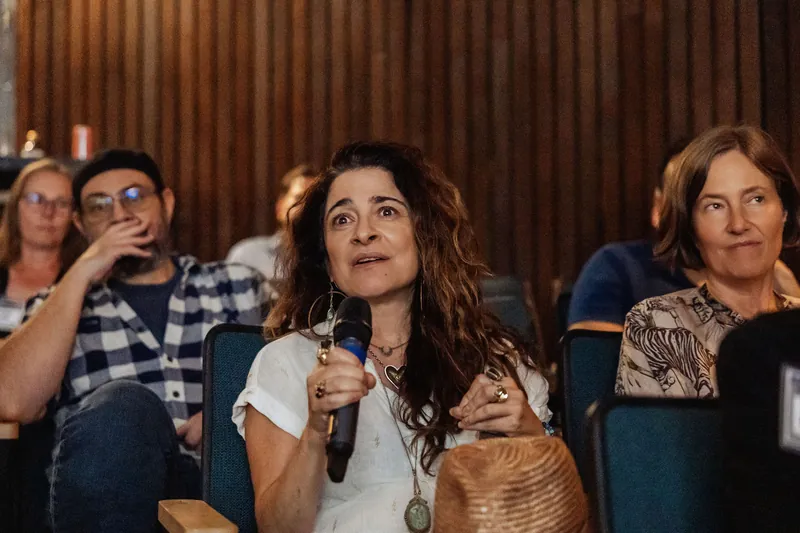 An attendee in the front rows asks a question with a microphone.