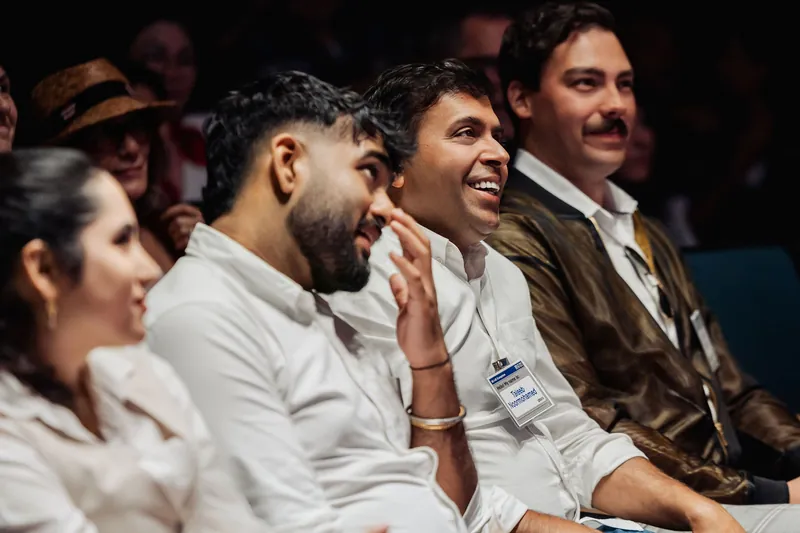Audience members smile and laugh together in the front rows.