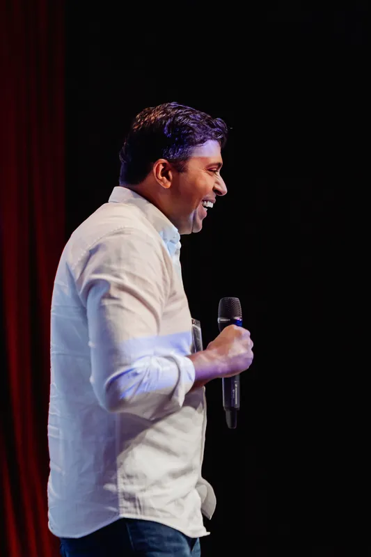 Taleeb Noormohamed pauses between points with the microphone at his side.