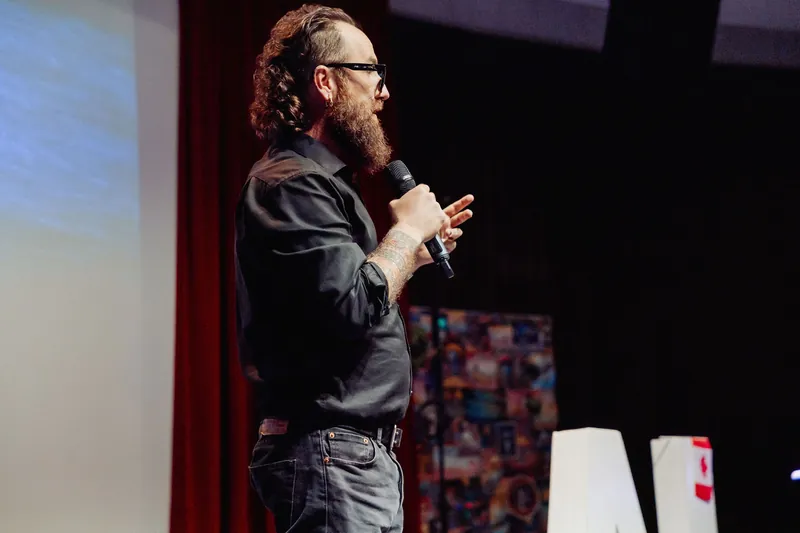 A side view shows the host continuing the opening remarks.