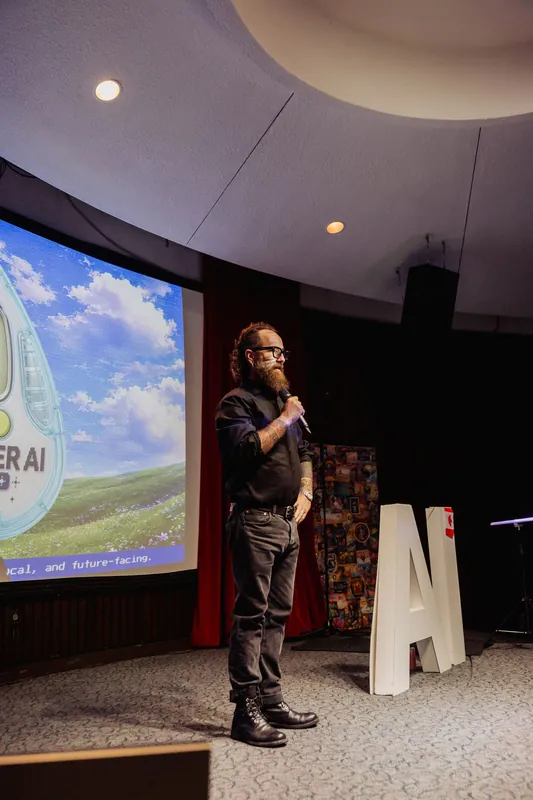 The host resumes the program in front of the Vancouver AI Meetup emblem.