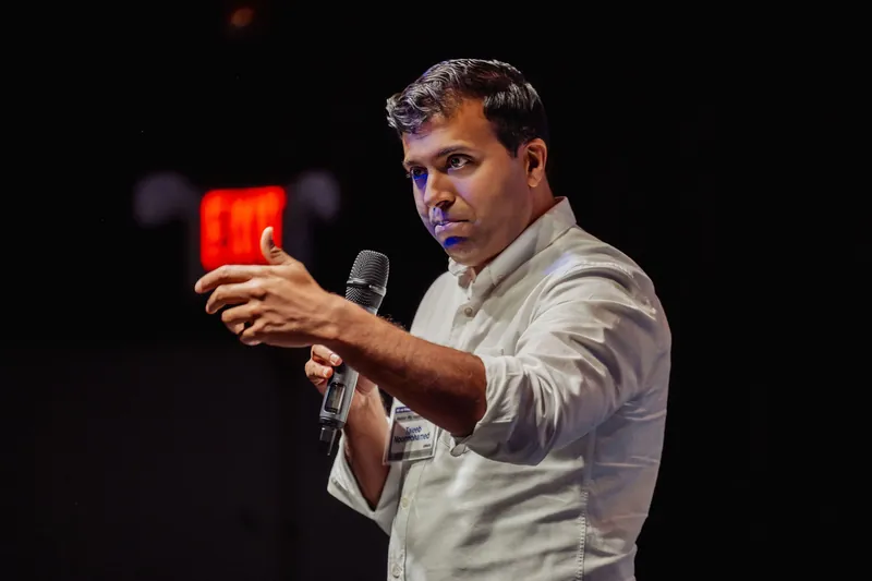 Taleeb Noormohamed points toward the audience during his talk.