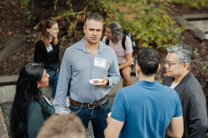 An overhead view captures several small conversations in the garden crowd.