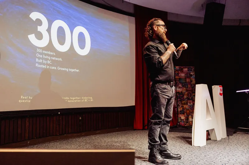 The host speaks beside a slide marking a 300th milestone.