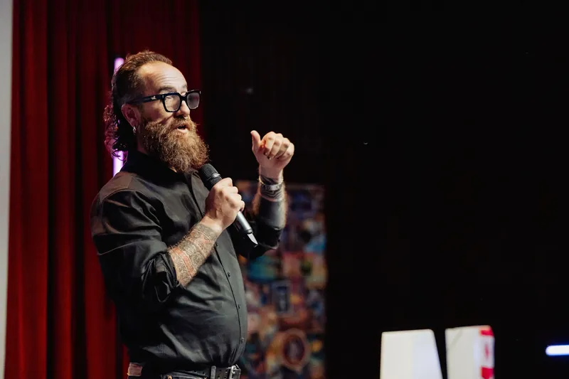 The host raises a finger to emphasize a point during the opening.