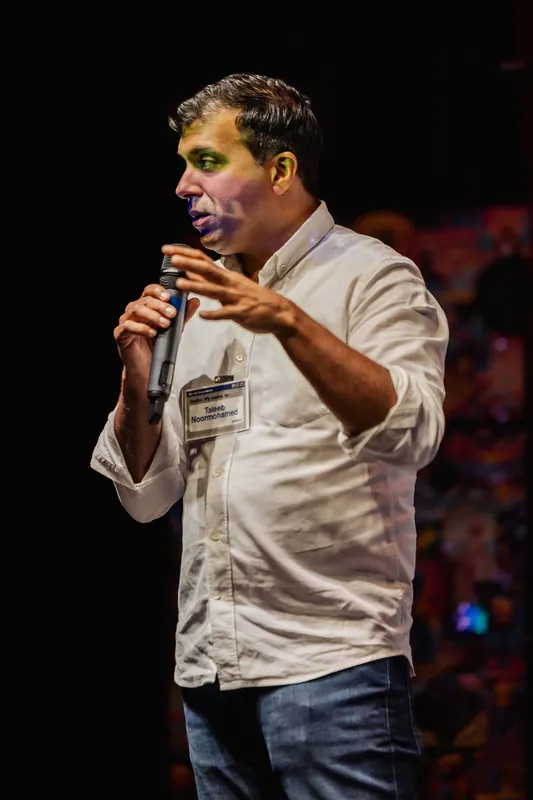 Taleeb Noormohamed gestures outward during his talk.