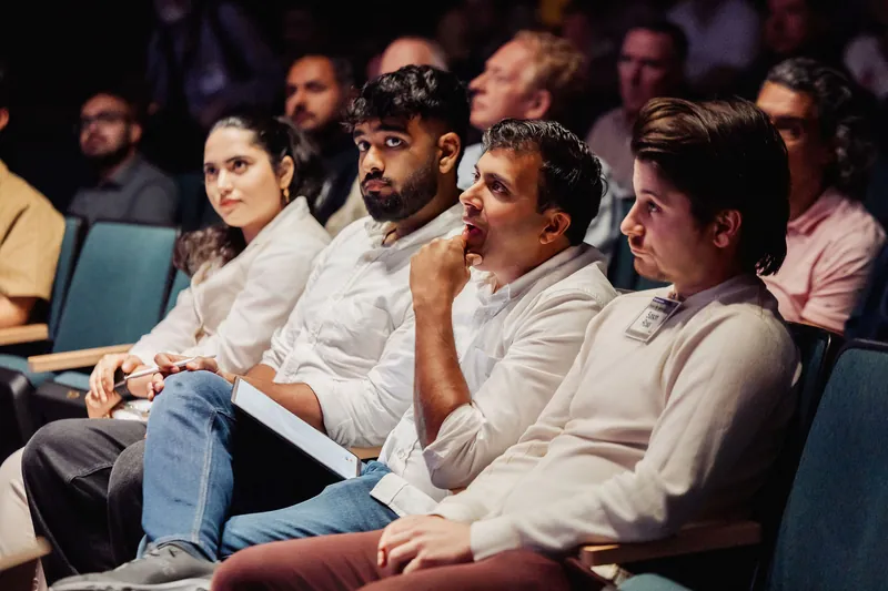 Audience members listen from the front rows of the auditorium.