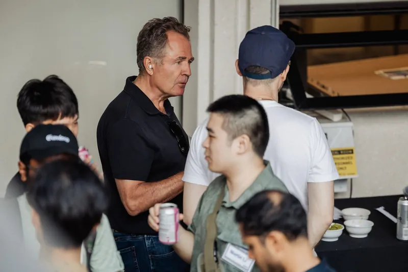 An attendee speaks to a small group gathered near the refreshments.