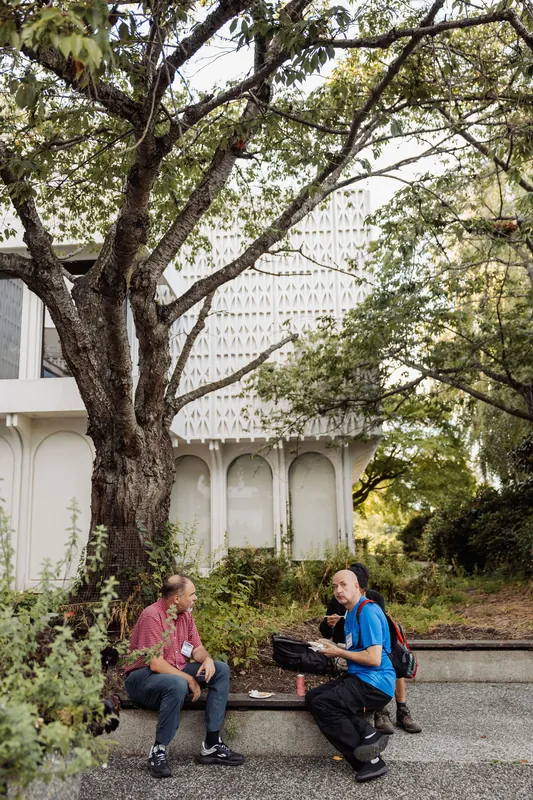 A mature tree shades the venue's distinctive white arched exterior.