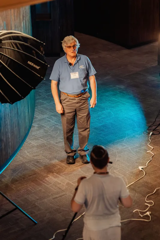 A guest stands in the blue-lit portrait area as the camera looks down from above.