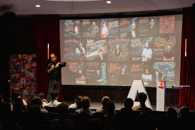 The host points toward the projected Futureproof Festival program.