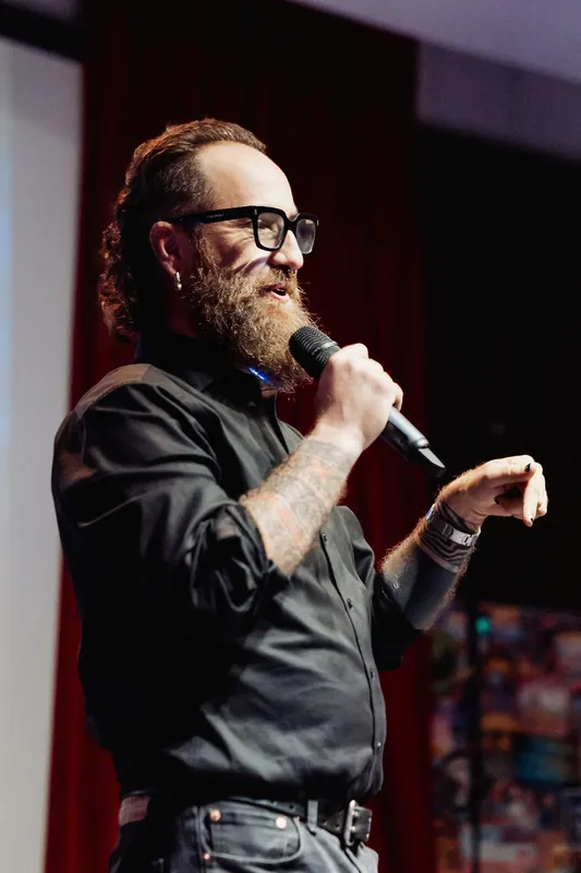 The host gestures with one hand during the presentation.