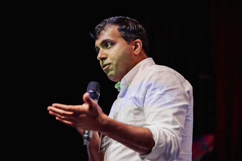 Taleeb Noormohamed continues an open-handed gesture in a close view.