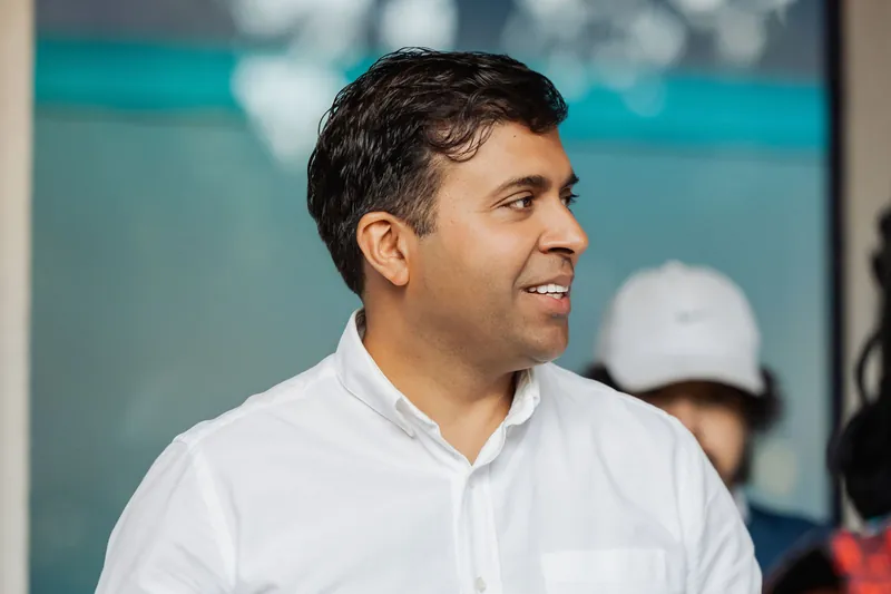 A close portrait catches an attendee smiling in the reception crowd.
