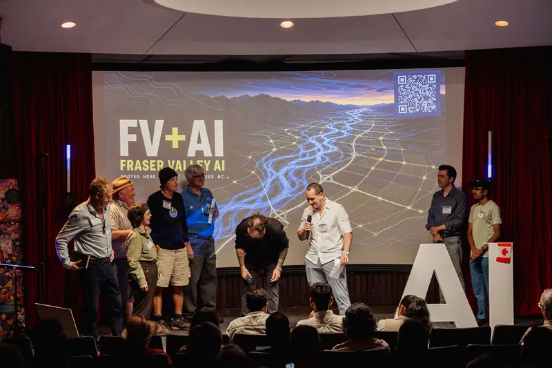 Fraser Valley AI representatives gather onstage beneath the FV+AI slide.
