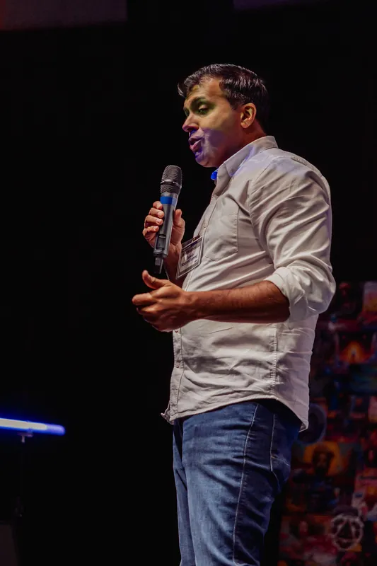 Taleeb Noormohamed speaks with one palm open in front of him.