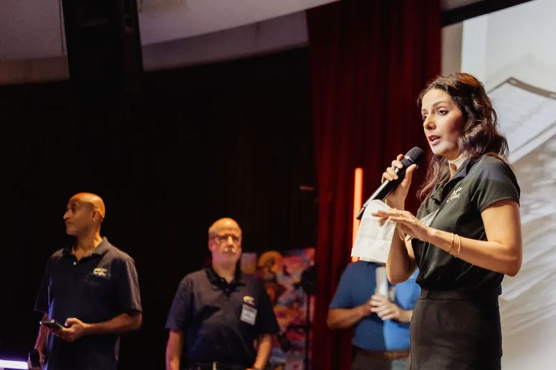 A presenter addresses the audience with Data for Good teammates behind her.