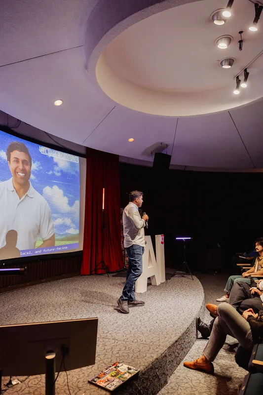 Taleeb Noormohamed speaks with his event portrait projected behind him.