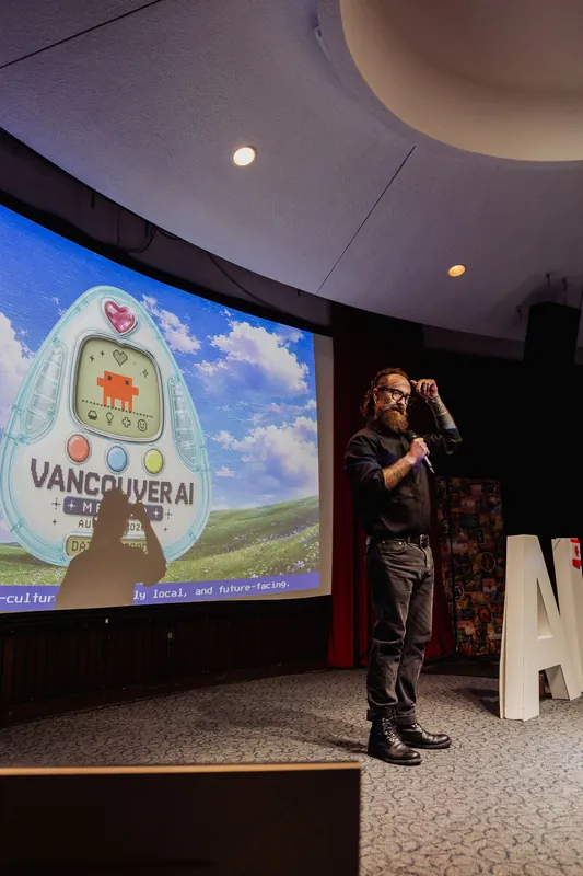 The host gestures beside the projected Vancouver AI Meetup emblem.